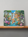 Colorful MDF wooden puzzle showing four playful tiger cubs by a waterfall with flowers and trees, displayed on a wooden shelf